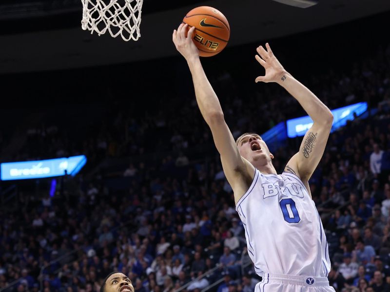 Feb 13, 2024; Provo, Utah, USA; Brigham Young Cougars forward Noah Waterman (0) lays the ball up past Central Florida Knights guard Darius Johnson (3) during the second half at Marriott Center. Mandatory Credit: Rob Gray-USA TODAY Sports