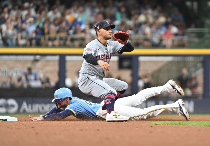 Aug 16, 2024; Milwaukee, Wisconsin, USA; Milwaukee Brewers second base Brice Turang (2) steals second base ahead of the tag by Cleveland Guardians second base Andres Gimenez (0) in the fourth inning at American Family Field. Mandatory Credit: Michael McLoone-USA TODAY Sports