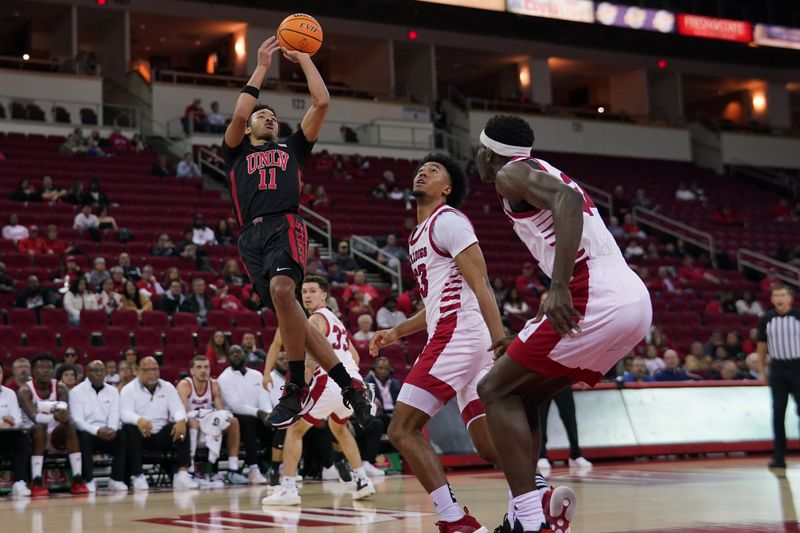 Feb 14, 2024; Fresno, California, USA; UNLV Rebels guard Dedan Thomas Jr. (11) shoots over Fresno State Bulldogs guard Xavier DuSell (53) in the first half at the Save Mart Center. Mandatory Credit: Cary Edmondson-USA TODAY Sports