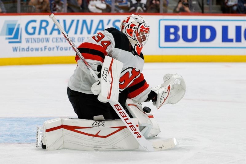 Feb 26, 2025; Denver, Colorado, USA; New Jersey Devils goaltender Jake Allen (34) makes a save in the second period against the Colorado Avalanche at Ball Arena. Mandatory Credit: Isaiah J. Downing-Imagn Images