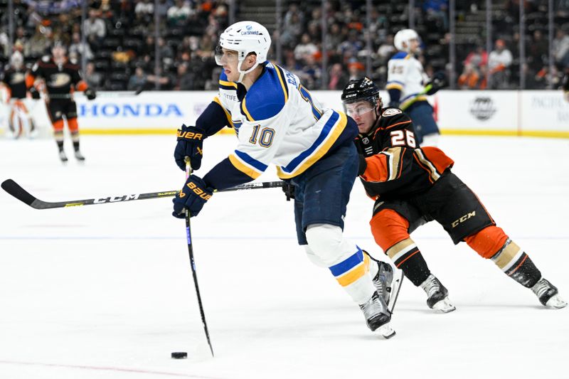 Mar 25, 2023; Anaheim, California, USA; St. Louis Blues center Brayden Schenn (10) looks to pass the puck while pressured by Anaheim Ducks left wing Brock McGinn (26) during the third period at Honda Center. Mandatory Credit: Kelvin Kuo-USA TODAY Sports