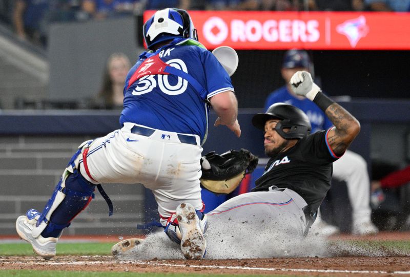 Sep 28, 2024; Toronto, Ontario, CAN;   Miami Marlins center fielder Dane Myers (54) is tagged out at home plate by Toronto Blue Jays catcher Alejandro Kirk (30) in the sixth inning at Rogers Centre. Mandatory Credit: Dan Hamilton-Imagn Images