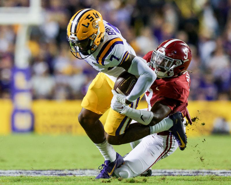 Nov 5, 2022; Baton Rouge, Louisiana, USA; LSU Tigers wide receiver Kayshon Boutte (7) is tackled by Alabama Crimson Tide defensive back Jordan Battle (9) during the second half at Tiger Stadium. Mandatory Credit: Stephen Lew-USA TODAY Sports