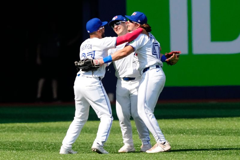 Jul 28, 2024; Toronto, Ontario, CAN; Toronto Blue Jays left fielder Steward Berrora (37) and center fielder Daulton Varsho (25) and right fielder Addison Barger (47) celebrate a win over Texas Rangers at Rogers Centre. Mandatory Credit: John E. Sokolowski-USA TODAY Sports