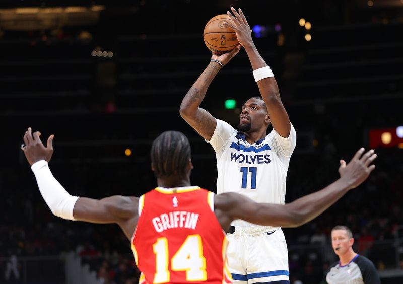 ATLANTA, GEORGIA - OCTOBER 30:  Naz Reid #11 of the Minnesota Timberwolves shoots a three-point basket against AJ Griffin #14 of the Atlanta Hawks during the first quarter at State Farm Arena on October 30, 2023 in Atlanta, Georgia.  NOTE TO USER: User expressly acknowledges and agrees that, by downloading and/or using this photograph, user is consenting to the terms and conditions of the Getty Images License Agreement.  (Photo by Kevin C. Cox/Getty Images)