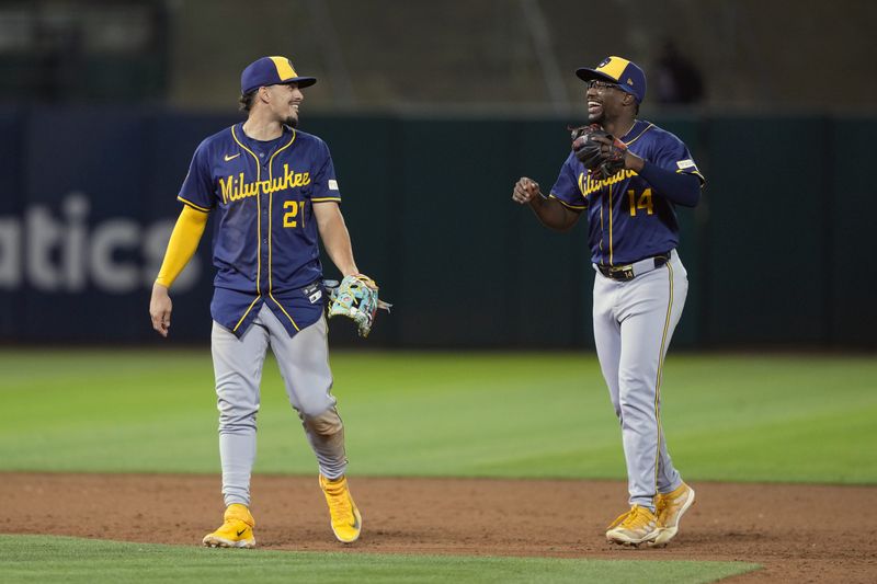 Aug 23, 2024; Oakland, California, USA; Milwaukee Brewers shortstop Willy Adames (27) and second baseman Andruw Monasterio (14) celebrate after defeating the Oakland Athletics at Oakland-Alameda County Coliseum. Mandatory Credit: Darren Yamashita-USA TODAY Sports