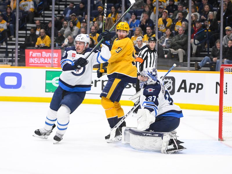 Jan 24, 2023; Nashville, Tennessee, USA;  Winnipeg Jets goaltender Connor Hellebuyck (37) makes a save from the deflection of Nashville Predators center Yakov Trenin (13) during the third period at Bridgestone Arena. Mandatory Credit: Steve Roberts-USA TODAY Sports