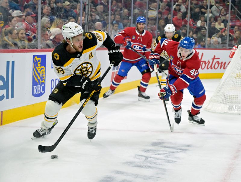 Apr 3, 2025; Montreal, Quebec, CAN; Boston Bruins forward David Pastrnak (88) plays the puck and Montreal Canadiens defenseman Lane Hutson (48) defends during the first period at the Bell Centre. Mandatory Credit: Eric Bolte-Imagn Images