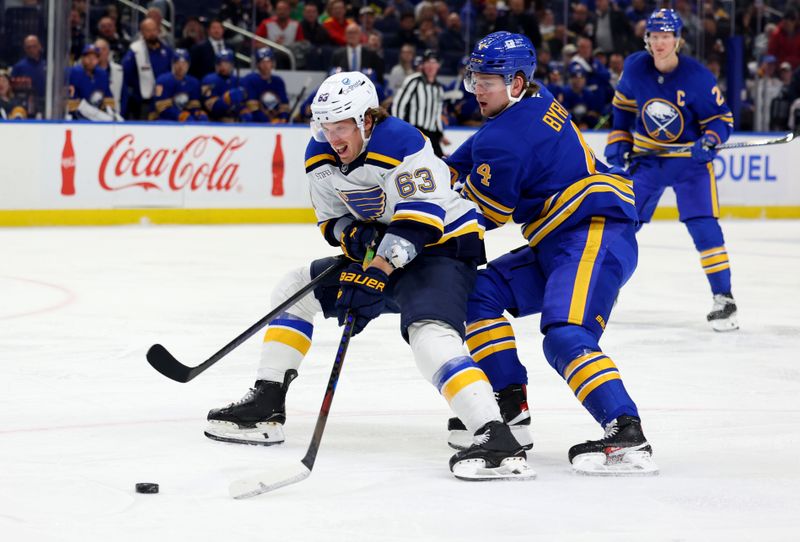 Nov 14, 2024; Buffalo, New York, USA;  St. Louis Blues left wing Jake Neighbours (63) skates with the puck as Buffalo Sabres defenseman Bowen Byram (4) defends during the first period at KeyBank Center. Mandatory Credit: Timothy T. Ludwig-Imagn Images