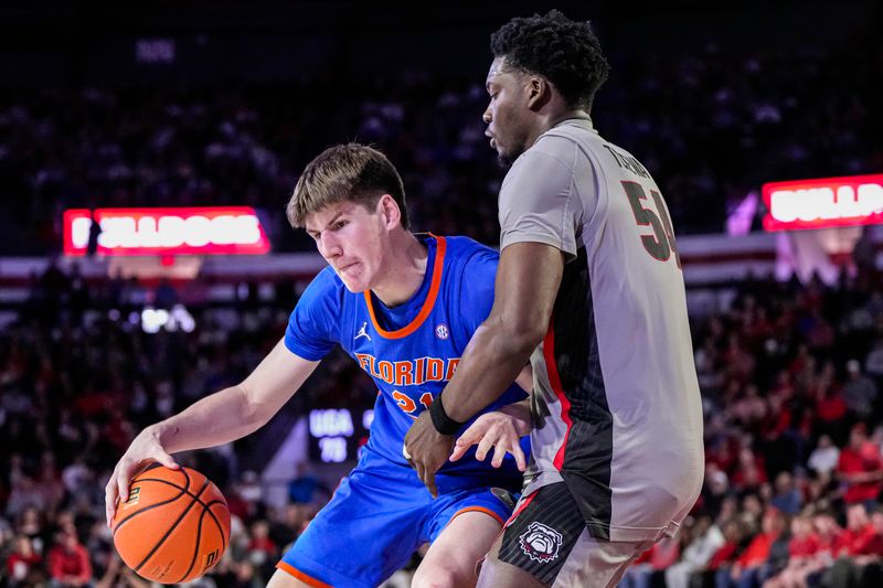 Feb 17, 2024; Athens, Georgia, USA; Florida Gators forward Alex Condon (21) dribbles against Georgia Bulldogs center Russel Tchewa (54) during the second half at Stegeman Coliseum. Mandatory Credit: Dale Zanine-USA TODAY Sports