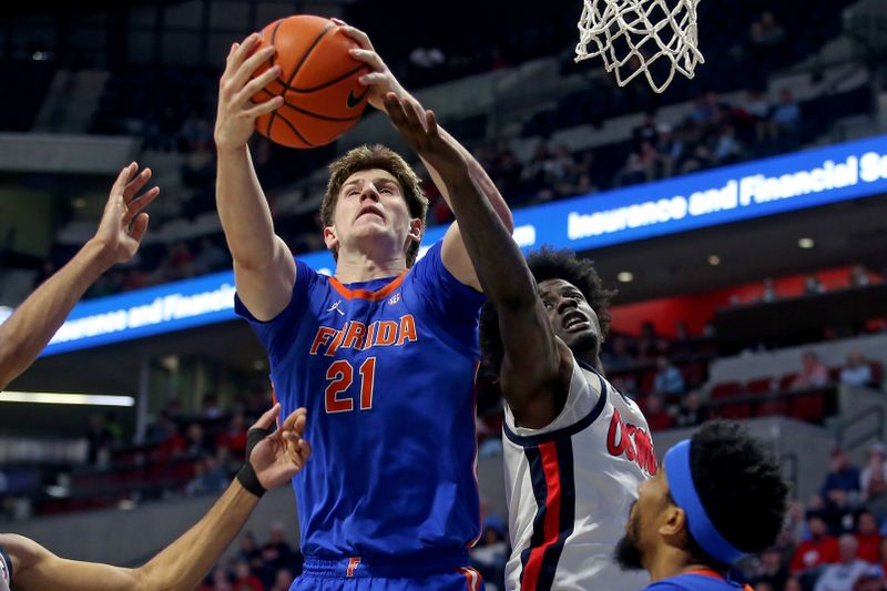 Feb 21, 2026; Oxford, Mississippi, USA; Florida Gators forward/center Alex Condon (21) collects a rebound over Mississippi Rebels forward Corey Chest (1) during the first half at The Sandy and John Black Pavilion at Ole Miss. Mandatory Credit: Petre Thomas-Imagn Images
