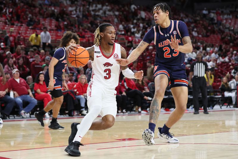 Jan 6, 2024; Fayetteville, Arkansas, USA; Arkansas Razorbacks guard El Ellis (3) drives against Auburn Tigers forward Addarin Scott (23) during the second half at Bud Walton Arena. Auburn won 83-51. Mandatory Credit: Nelson Chenault-USA TODAY Sports