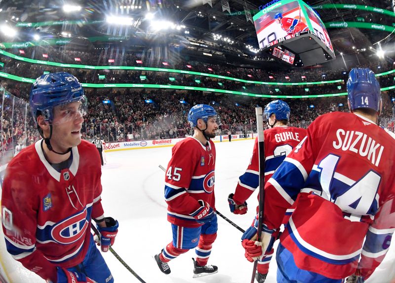 Jan 25, 2025; Montreal, Quebec, CAN; Montreal Canadiens forward Juraj Slafkovsky (20) and teammates defenseman Alexandre Carrier (45) and forward Nick Suzuki (14) celebrate the goal scored by teammate Montreal Canadiens forward Cole Caufield (13) (not pictured) against the New Jersey Devils during the second period at the Bell Centre. Mandatory Credit: Eric Bolte-Imagn Images