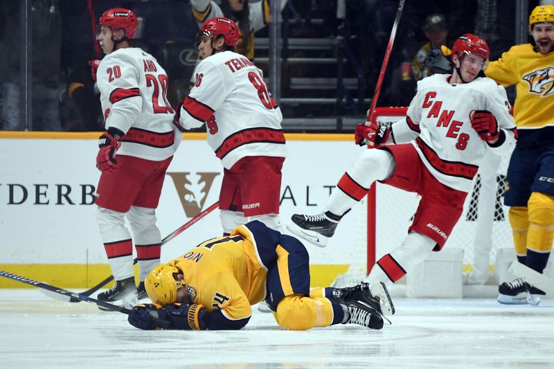 Dec 27, 2023; Nashville, Tennessee, USA; Nashville Predators center Gustav Nyquist (14) falls to the ice after a collision with Carolina Hurricanes right wing Andrei Svechnikov (37) after a goal during the second period at Bridgestone Arena. Mandatory Credit: Christopher Hanewinckel-USA TODAY Sports