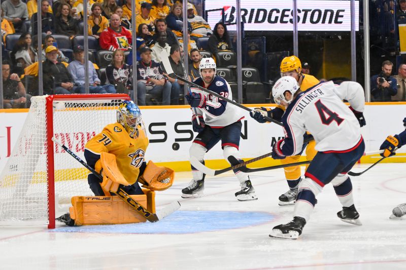 Oct 9, 2025; Nashville, Tennessee, USA; Nashville Predators goaltender Juuse Saros (74) blocks the shot of Columbus Blue Jackets center Cole Sillinger (4) during the third period at Bridgestone Arena. Mandatory Credit: Steve Roberts-Imagn Images