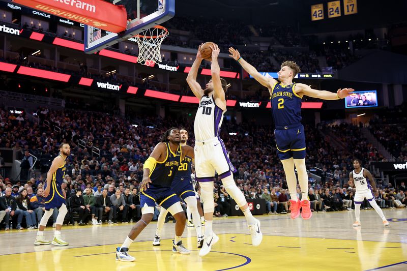 SAN FRANCISCO, CALIFORNIA - JANUARY 25:  Domantas Sabonis #10 of the Sacramento Kings goes up for a shot on Kevon Looney #5 and Brandin Podziemski #2 of the Golden State Warriors in the first half at Chase Center on January 25, 2024 in San Francisco, California. NOTE TO USER: User expressly acknowledges and agrees that, by downloading and or using this photograph, User is consenting to the terms and conditions of the Getty Images License Agreement.  (Photo by Ezra Shaw/Getty Images)