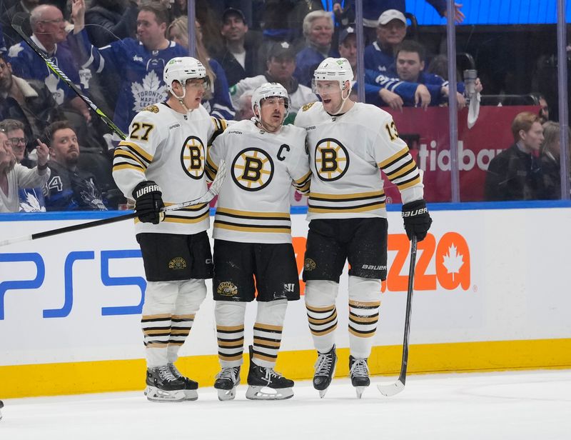 Apr 24, 2024; Toronto, Ontario, CAN; Boston Bruins defenseman Hampus Lindholm (27) and forward Charlie Coyle (13) congratulate forward Brad Marchand (63) on his second goal of the game against the Toronto Maple Leafs during the third period of game three of the first round of the 2024 Stanley Cup Playoffs at Scotiabank Arena. Mandatory Credit: John E. Sokolowski-USA TODAY Sports