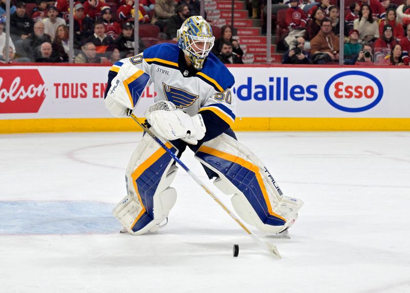 Feb 11, 2024; Montreal, Quebec, CAN; St.Louis Blues goalie Jordan Binnington (50) plays the puck during the second period of the game against the Montreal Canadiens at the Bell Centre. Mandatory Credit: Eric Bolte-USA TODAY Sports