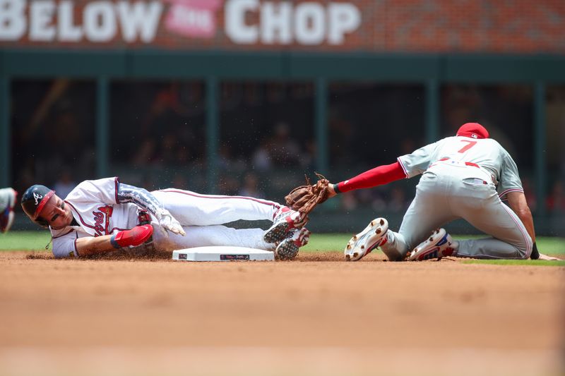 Jul 7, 2024; Atlanta, Georgia, USA; Atlanta Braves center fielder Jarred Kelenic (24) slides safely into second with a stolen base past the tag of Philadelphia Phillies shortstop Trea Turner (7) in the first inning at Truist Park. Mandatory Credit: Brett Davis-USA TODAY Sports
