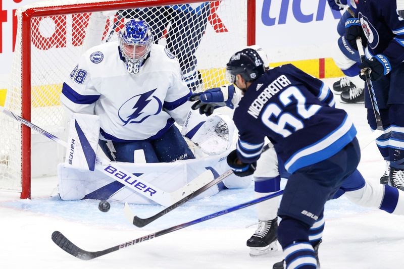 Jan 2, 2024; Winnipeg, Manitoba, CAN; Tampa Bay Lightning goaltender Andrei Vasilevskiy (88) blocks a shot from Winnipeg Jets right wing Nino Niederreiter (62) in the third period at Canada Life Centre. Mandatory Credit: James Carey Lauder-USA TODAY Sports