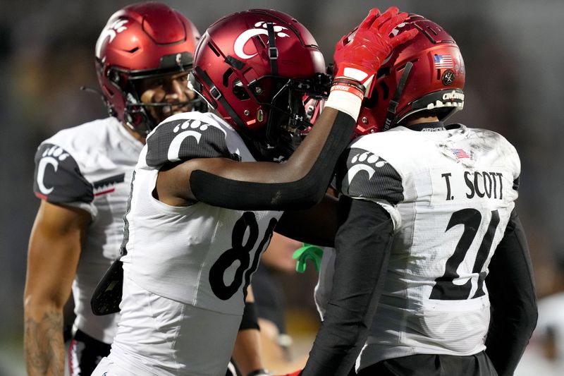 Oct 29, 2022; Orlando, Florida, USA; Cincinnati Bearcats wide receiver Tyler Scott (21) celebrates with wide receiver Chris Scott (80) after a two-point conversion catch against the UCF Knights in the fourth quarter at FBC Mortgage Stadium. UCF won 25-21. Mandatory Credit: Kareem Elgazzar/The Cincinnati Enquirer Sentinel via USA TODAY NETWORK