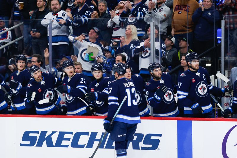 Nov 5, 2024; Winnipeg, Manitoba, CAN;  Winnipeg Jets forward Gabriel Vilardi (13) is congratulated by his team mates on his goal against the Utah Hockey Club during the second period at Canada Life Centre. Mandatory Credit: Terrence Lee-Imagn Images