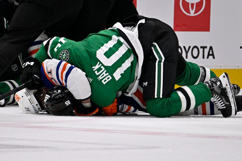 May 21, 2025; Dallas, Texas, USA; Dallas Stars center Oskar Bäck (10) and Edmonton Oilers defenseman Troy Stecher (51) fight in the third period during game one of the Western Conference Final of the 2025 Stanley Cup Playoffs at American Airlines Center. Mandatory Credit: Jerome Miron-Imagn Images