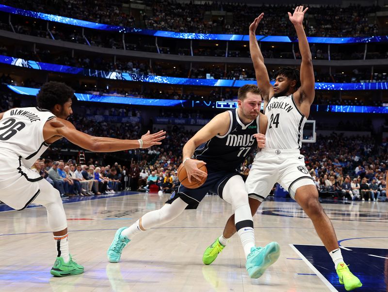 DALLAS, TEXAS - OCTOBER 27: Luka Doncic #77 of the Dallas Mavericks drives the ball between Spencer Dinwiddie #26 (L) and Cam Thomas #24 of the Brooklyn Nets in the second quarter at American Airlines Center on October 27, 2023 in Dallas, Texas. NOTE TO USER: User expressly acknowledges and agrees that, by downloading and or using this photograph, User is consenting to the terms and conditions of the Getty Images License Agreement. (Photo by Richard Rodriguez/Getty Images)