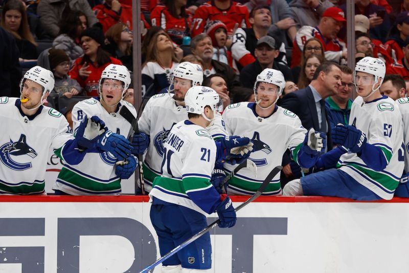 Feb 11, 2024; Washington, District of Columbia, USA; Vancouver Canucks left wing Nils Hoglander (21) celebrates with teammates after scoring a goal against the Washington Capitals in the second period at Capital One Arena. Mandatory Credit: Geoff Burke-USA TODAY Sports