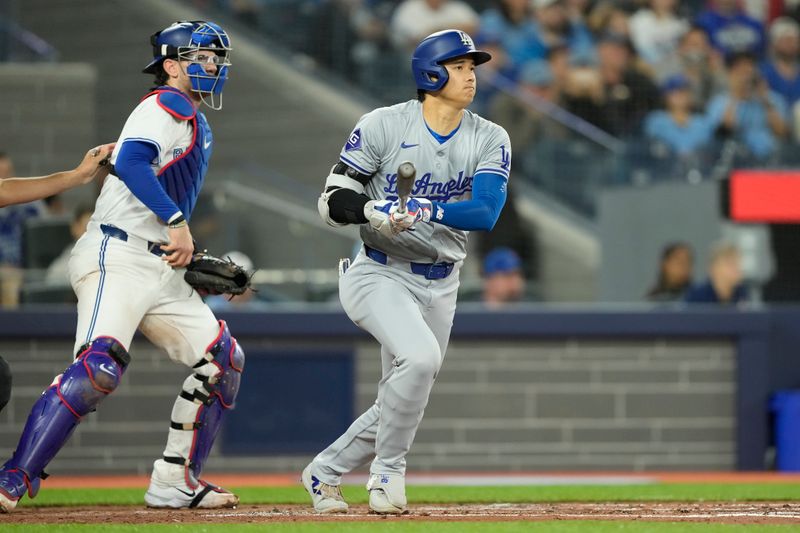 Apr 27, 2024; Toronto, Ontario, CAN; Los Angeles Dodgers designated hitter Shohei Ohtani (17) hits a one run single against the Toronto Blue Jays during the second inning at Rogers Centre. Mandatory Credit: John E. Sokolowski-USA TODAY Sports