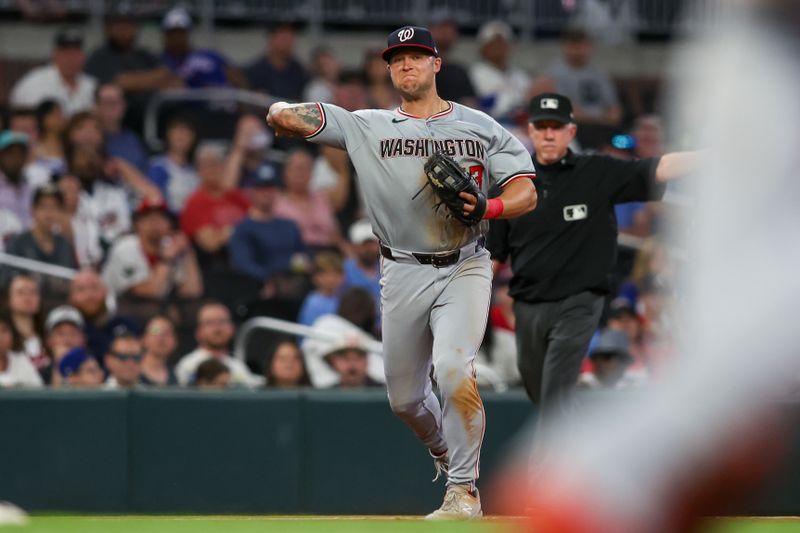 May 28, 2024; Atlanta, Georgia, USA; Washington Nationals third baseman Nick Senzel (13) throws a runner out at first against the Atlanta Braves in the eighth inning at Truist Park. Mandatory Credit: Brett Davis-USA TODAY Sports