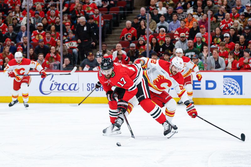 Jan 15, 2026; Chicago, Illinois, USA; Chicago Blackhawks left wing Nick Foligno (17) battles for the puck with Calgary Flames defenseman MacKenzie Weegar (52) during the first period at United Center. Mandatory Credit: Kamil Krzaczynski-Imagn Images