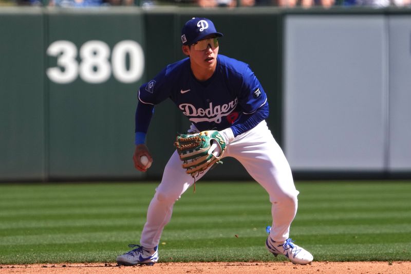 Mar 1, 2025; Phoenix, Arizona, USA; Los Angeles Dodgers second base Hyeseong Kim (6) fields a ground ball against the San Francisco Giants during the third inning at Camelback Ranch-Glendale. Mandatory Credit: Joe Camporeale-Imagn Images