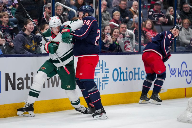 Jan 6, 2024; Columbus, Ohio, USA;  Columbus Blue Jackets right winger Mathieu Olivier (24) scrums with Minnesota Wild defenseman Jon Merrill (4) along the boards in the first period at Nationwide Arena. Mandatory Credit: Aaron Doster-USA TODAY Sports