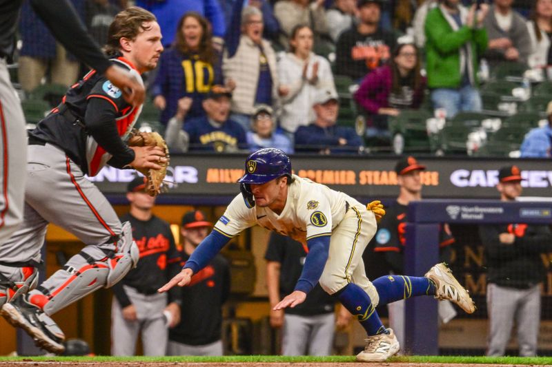 May 21, 2025; Milwaukee, Wisconsin, USA;  Milwaukee Brewers right fielder Sal Frelick (10) scores a run in the ninth inning as Baltimore Orioles catcher Adley Rutschman (35) looks on at American Family Field. Mandatory Credit: Benny Sieu-Imagn Images