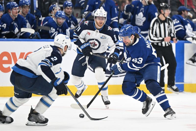 Jan 1, 2026; Toronto, Ontario, CAN;  Toronto Maple Leafs forward Matias Maccelli (63) skates with the puck past Winnipeg Jets defenseman Dylan DeMelo (2) and forward Kyle Connor (81) in the third period at Scotiabank Arena. Mandatory Credit: Dan Hamilton-Imagn Images
