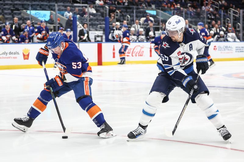 Mar 4, 2025; Elmont, New York, USA;  New York Islanders center Casey Cizikas (53) and Winnipeg Jets center Mark Scheifele (55) battle for control of the puck in the second period at UBS Arena. Mandatory Credit: Wendell Cruz-Imagn Images