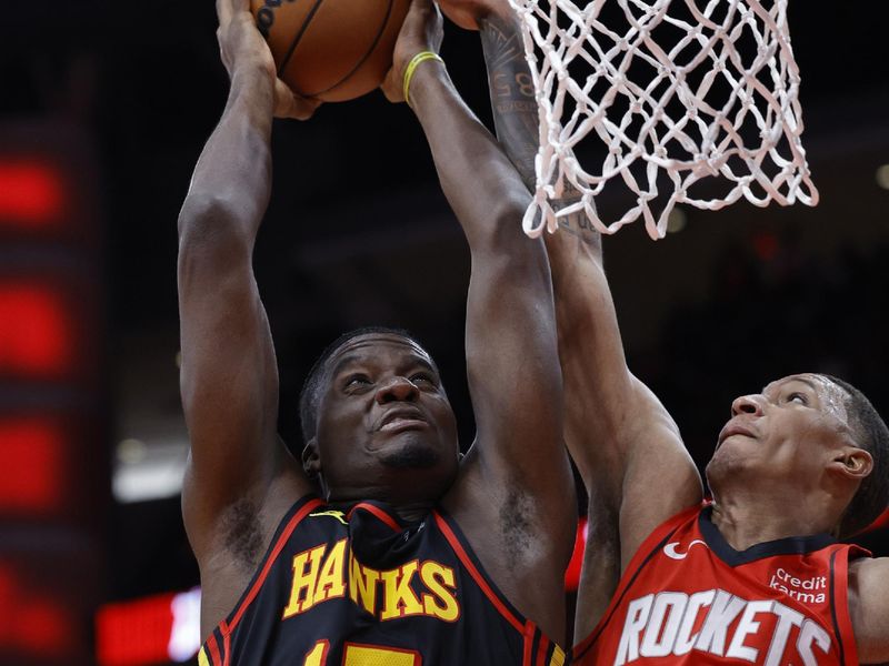 HOUSTON, TEXAS - DECEMBER 20: Clint Capela #15 of the Atlanta Hawks drives to the net ahead of Jabari Smith Jr. #10 of the Houston Rockets during the first half at Toyota Center on December 20, 2023 in Houston, Texas. User expressly acknowledges and agrees that, by downloading and or using this photograph, User is consenting to the terms and conditions of the Getty Images License Agreement.?  (Photo by Carmen Mandato/Getty Images)