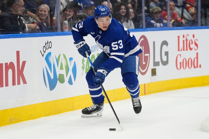 Oct 28, 2025; Toronto, Ontario, CAN; Toronto Maple Leafs forward Easton Cowan (53) carries the puck against the Calgary Flames during the first period at Scotiabank Arena. Mandatory Credit: John E. Sokolowski-Imagn Images