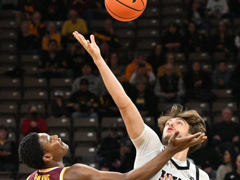 Feb 11, 2024; Iowa City, Iowa, USA; Iowa Hawkeyes forward Owen Freeman (32) and Minnesota Golden Gophers forward Pharrel Payne (21) battle for the opening tipoff during the first half at Carver-Hawkeye Arena. Mandatory Credit: Jeffrey Becker-USA TODAY Sports