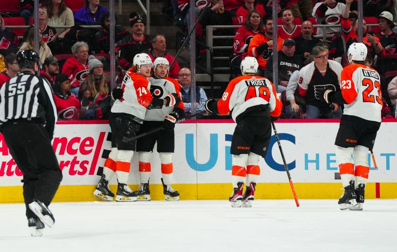 Mar 21, 2024; Raleigh, North Carolina, USA; Philadelphia Flyers right wing Travis Konecny (11) is congratulated by right wing Owen Tippett (74) and  center Morgan Frost (48) after his goal against the Carolina Hurricanes during the third period at PNC Arena. Mandatory Credit: James Guillory-USA TODAY Sports