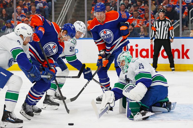 Apr 13, 2024; Edmonton, Alberta, CAN; Edmonton Oilers forward forward Warren Foegele (37) and forward Corey Perry (90) try to get to a loose puck in front of Vancouver Canucks goaltender Casey DeSmith (29) during the first period at Rogers Place. Mandatory Credit: Perry Nelson-USA TODAY Sports