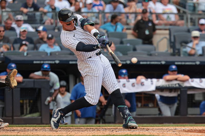 Aug 4, 2024; Bronx, New York, USA; New York Yankees left fielder Aaron Judge (99) singles during the third inning against the Toronto Blue Jays at Yankee Stadium. Mandatory Credit: Vincent Carchietta-USA TODAY Sports