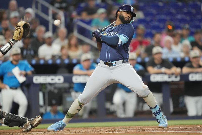 May 18, 2025; Miami, Florida, USA;  Tampa Bay Rays third baseman Junior Caminero (13) leans back on an inside pitch in the Hird inning against the Miami Marlins at loanDepot Park. Mandatory Credit: Jim Rassol-Imagn Images