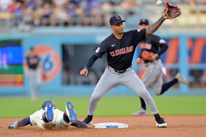 Sep 7, 2024; Los Angeles, California, USA;  The ball gets by Cleveland Guardians shortstop Brayan Rocchio (4) on a pick off attempt on Los Angeles Dodgers shortstop Mookie Betts (50) in the first inning at Dodger Stadium. Mandatory Credit: Jayne Kamin-Oncea-Imagn Images