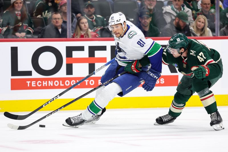 Dec 3, 2024; Saint Paul, Minnesota, USA; Vancouver Canucks center Dakota Joshua (81) skates with the puck as Minnesota Wild defenseman Declan Chisholm (47) defends during the first period at Xcel Energy Center. Mandatory Credit: Matt Krohn-Imagn Images