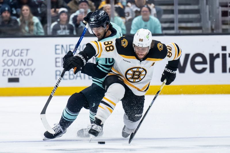 Feb 23, 2023; Seattle, Washington, USA; Seattle Kraken forward Matty Beniers (10) and Boston Bruins forward David Pastrnak (88) battle for the puck during the first period at Climate Pledge Arena. Mandatory Credit: Stephen Brashear-USA TODAY Sports