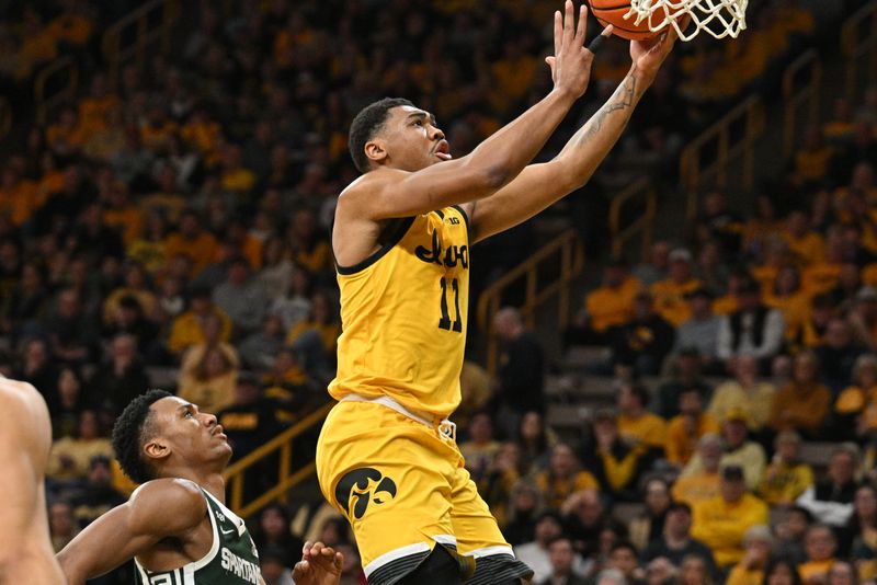 Feb 25, 2023; Iowa City, Iowa, USA; Iowa Hawkeyes guard Tony Perkins (11) goes to the basket as Michigan State Spartans guard Tyson Walker (2) looks on during the second half at Carver-Hawkeye Arena. Mandatory Credit: Jeffrey Becker-USA TODAY Sports