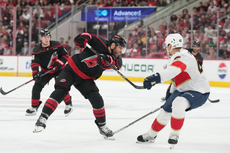 May 20, 2025; Raleigh, North Carolina, USA; Carolina Hurricanes forward Sebastian Aho (20) shoots the puck against Florida Panthers defenseman Gustav Forsling (42) during the first period in game one of the Eastern Conference Final of the 2025 Stanley Cup Playoffs at Lenovo Center. Mandatory Credit: James Guillory-Imagn Images