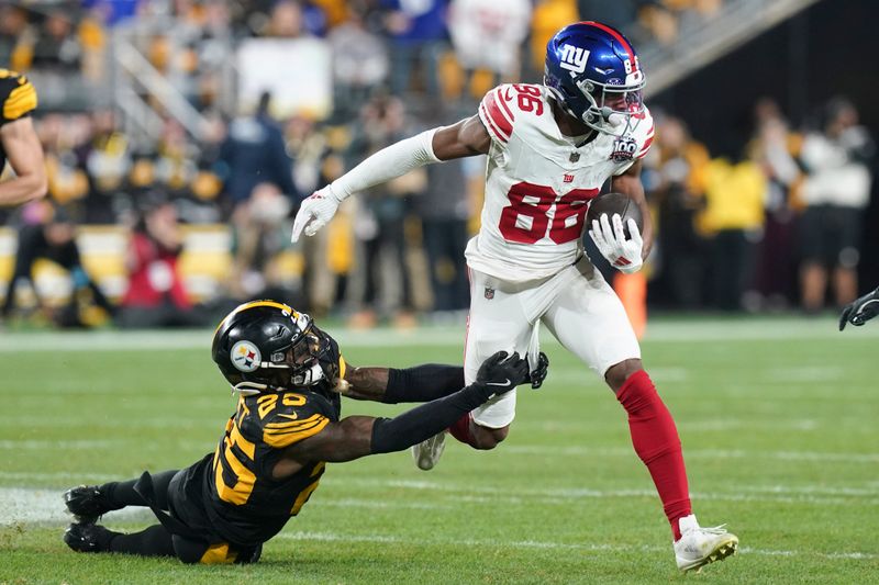 New York Giants wide receiver Darius Slayton (86) avoids a tackle from Pittsburgh Steelers safety DeShon Elliott (25) during the first half of an NFL football game Monday, Oct. 28, 2024, in Pittsburgh. (AP Photo/Matt Freed)